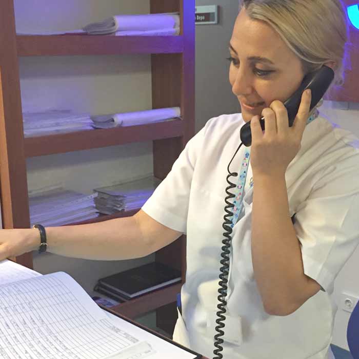 uma mulher de bata branca a falar ao telefone