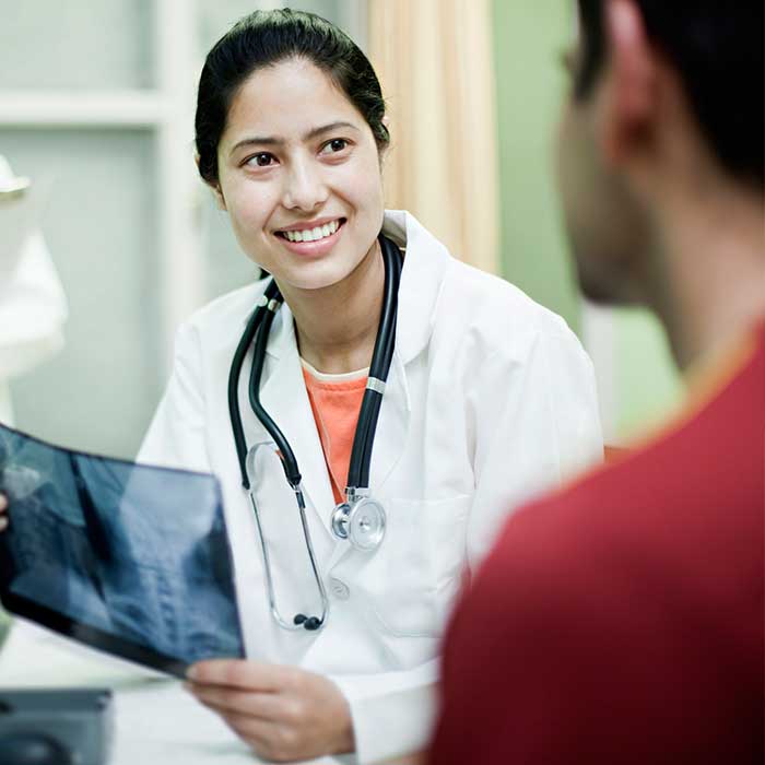 um m&eacute;dico a mostrar um raio-x a um paciente