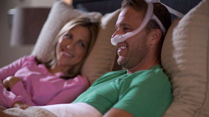 um homem e uma mulher deitados num sof&aacute;