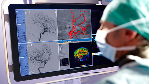 um m&eacute;dico a olhar para um ecr&atilde; de computador