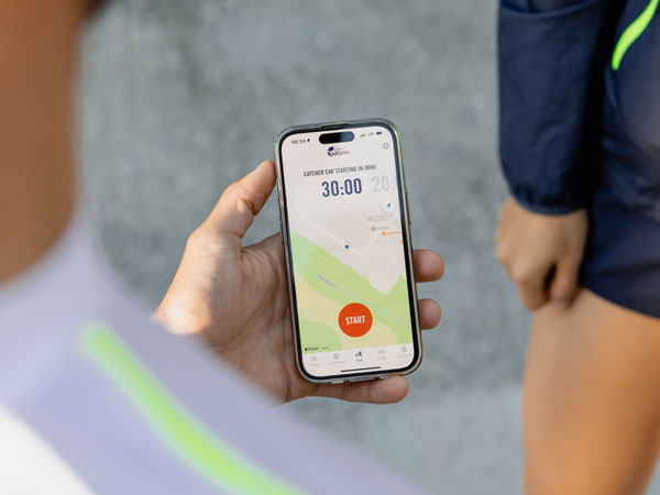 Um participante na corrida est&aacute; a verificar o telem&oacute;vel, &agrave; espera que a corrida comece.